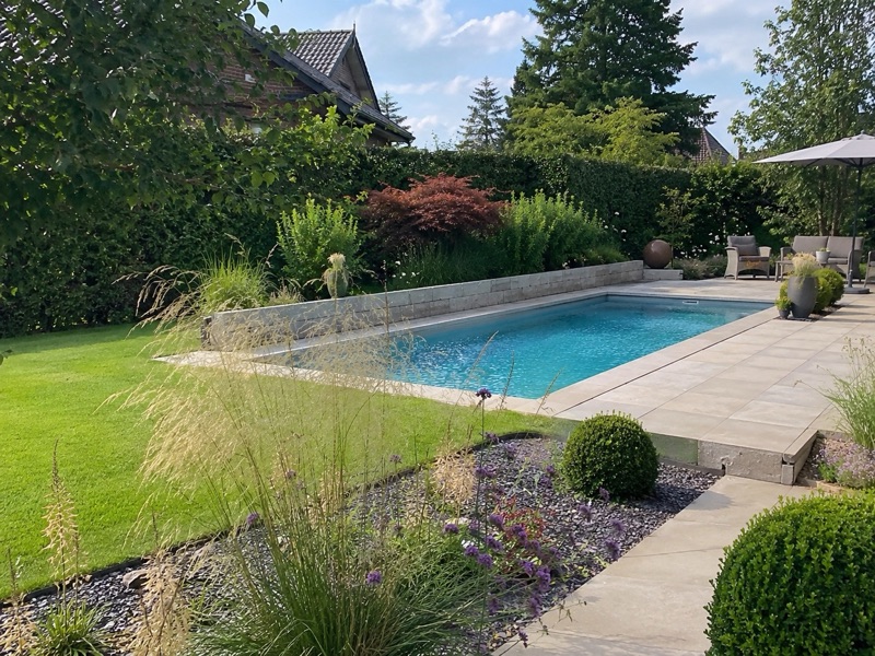 Poolnaher Gartenbereich mit Pflanzenrahmung und Ruhezone